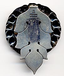 This bookmark was made in Denmark by Georg Jensen. It is marked GI, 61, and Sterling Denmark. This is an old mark used before 1920. The bookmark is in the shape of a wreath with the center in the shape of a heart.