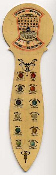 This bookmark was made in the US by The American Art Works of Coshocton, Ohio. It is a celluloid advertising bookmark for the Kellogg Furniture Co. It is a calendar for the years 1910 - 1915 with a rotating dial in the back. The instructions read "Turn wheel until month appears in column with present year. Top will show days of the week. Use 1912 printed in red for JAN. and FEB (Leap Year)." It also has the birth stones for each month.  