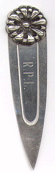 This bookmark is American made by The Napier Company. It is marked Napier Sterling. The top of the bookmark is in the shape of a flower. The date is somewhere after 1922.