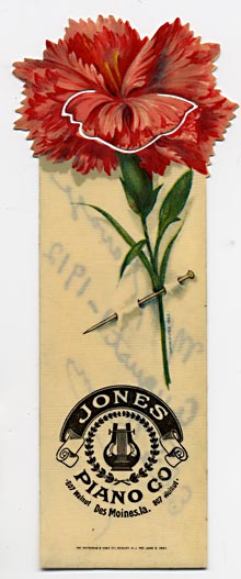  This bookmark was made in the US by the Whitehead and Hoag Co. of Newark NJ. It is a celluloid advertising bookmark with acarnation flower on top and advertising Jones Piano Co in Des Moines, Iowa. The back dates this piece at August 1, 1912 as a gift.  