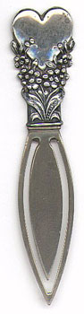 This bookmark is American made but only marked Sterling. The date and manufacturer are unknown. It is in the shape of a flower holding up a heart. Only the top part is silver.