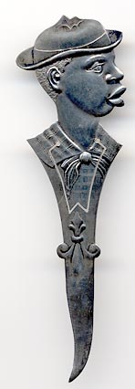 This bookmark was made in the US by E.H.H. Smith Silver Co. It is marked Sterling with the manufacturers mark. The bookmark is a figural of an African American boy with a derby hat. The back is a scene with mountains and trees an it says Ashville, NC. The date is 1904 - 1920.
