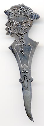 This bookmark was made in the US by E.H.H. Smith Silver Co. It is marked Sterling with the manufacturers mark. The bookmark is a figural of an African American boy with a derby hat. The back is a scene with mountains and trees an it says Ashville, NC. The date is 1904 - 1920.
