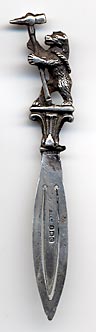 This bookmark is made in Birmingham, England. It is marked with the the date mark of 1927 and the hallmarks for Birmingham. It has a figural bear holding a large pick axe.