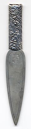 This bookmark was made in the US by Gorham. It is very similar to one from the 1888 catalog. It is marked with the Gorham hallmarks and the catalog number 26. The top blade is full of flowers. The date is 1885 - 1895.