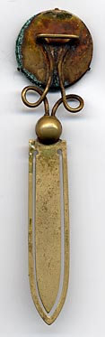  This bookmark was made in France. It is brass and the top is a relief picture of a kitty with light green glass eyes. The date is 1890 - 1910.  