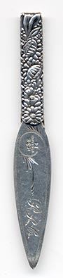  This bookmark was made in the US by Gorham. It is marked with the manufacturers hallmark and 14. This is one of the 33 bookmarks from the Autumn 1888 Gorham catalog. The handle and top blade have a array of flowers and leaves. The date is 1888.  