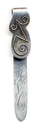 This bookmark was made in the US by Shiebler. It is marked with the Shiebler hallmark, sterling and 39x. The top is some funky design in a different metal, possibly gold.  The date is 1900 - 1910.
