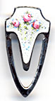 This bookmark was made in the US byF.A. Hermann Co. It has a hallmark on the back along with the word sterling. The top and the inner blade are finished in white enamel with flowers. The date is 1900 - 1910. 