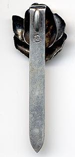 This bookmark was made in the US by Unger Bros. It is hallmarked with the manufacturers mark of an intertwined U and B. The top is a rose flower just starting to bloom. To see the catalog page select "Catalog Unger Bros 1904" from the Books, Catalogs and Patents dropdown menu.