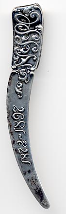 This bookmark was made in the US by Gorham. It is hallmarked on the back with the Gorham mark of lion, anchor, G and the date letter M signifying 1880. The top blade has a fancy design which could possibly be letter for some organization and the date 1872 - 1897.
