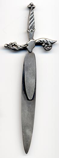 This bookmark was made in the US by Reddall & Co. It is marked with their hallmark of a crown. The bookmark is in the shape of a sword.
