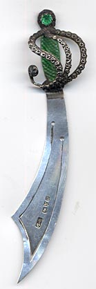 This sterling bookmark was made made at Halifax in Yorkshire, England by Charles Horner in 1902 according to the hallmarks. It is in the shape of a sword with a green enamel handle topped with a green gemstone. 