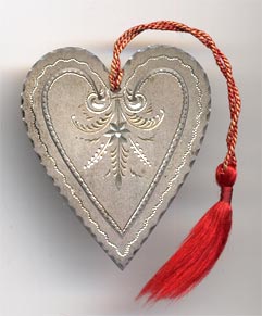 This bookmark was made in the US by an unknown manufacturer. It is in the shape of a heart with an inscribed design on the inner blade. The back is marked sterling and has the inscription "E.H. Sep. 10 '98". A red tassel is attached at the top.