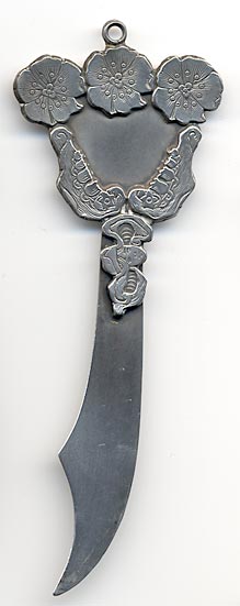 This bookmark was made in the US by an unknown manufacturer. It is marked sterling 925/1000 on the back. The top design has three flowers on top, two lily of the valley flowers on the sides and the small top blade is a picture of a girls head with large looping pigtails.