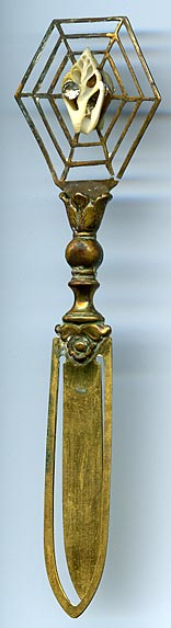 This bookmark was made in Europe  by an unknown manufacturer. It is made of brass with a tiny shell and rhinestone in what looks like a  spider web.