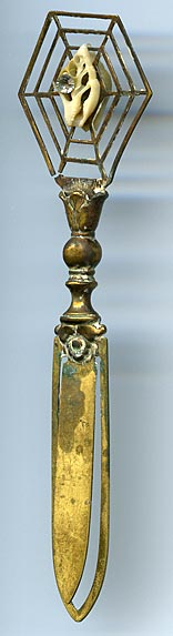 This bookmark was made in Europe  by an unknown manufacturer. It is made of brass with a tiny shell and rhinestone in what looks like a  spider web.