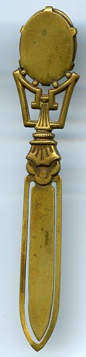 This bookmark was made in France. It is unmarked gilded brass and has a cameo on top. The date is 1890 - 1910.