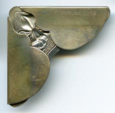 This bookmark was made in the US by Gorham. It is marked Gorham sterling 1396 on the back. It is in the shape of a corner with a flowers.