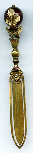 This brass bookmark was made in Europe and is in the shape of a thistle with an agate marble between the leaves.