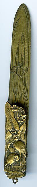 This bookmark was made in Japan. It is brass and has a high relief pictures of birds and flowers. The date is 1900 - 1910.