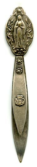 This bookmark was made in France. It is made of silver plate over brass. The top is a picture of a woman praying with long robes. A religious symbol no doubt. On the top blade is a crest with the initials ND.