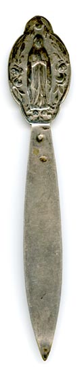 This bookmark was made in France. It is made of silver plate over brass. The top is a picture of a woman praying with long robes. A religious symbol no doubt. On the top blade is a crest with the initials ND.