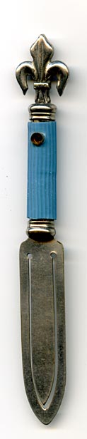 This bookmark is made in France and is a Stanhope or 'peeper'" bookmark. It is probably silver plate over brass on the fleur de lis on top and brass blades. It was made between 1890 and 1920. If you look through the '"peep hole'" you can see 4 photographs of different scenes with '"A Memory of Peterborough'" in the center. The scenes are: (counter clockwise from the top) '"West Front Peterborough Cathedral'", '"Nave West'", Nave East'", and The Cathedral form the North East'". It also says Made in France."