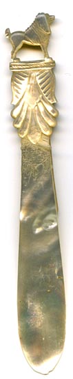 This bookmark was made in France. It is a French Palais Royal mother-of-pearl hand carved figural dog sitting up on a pedestal. The date is 1880 - 1900.