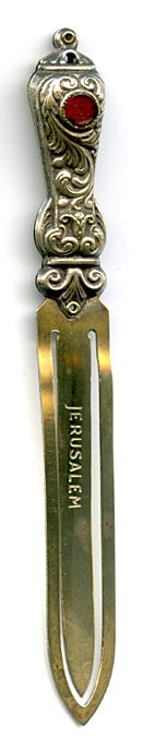 This bookmark was made in Israel by an unknown manufacturer. It is unmarked except for the printed inscription on middle blade marked Jerusalem. The top is an ornate design with a red glass jewel. 