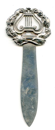This bookmark was made in the US by Gorham Mfg. Co. It  is marked with the manufacturers hallmark, 1495M and an anchor as the date mark for 1887. The top is lyre surrounded by olive leaves.