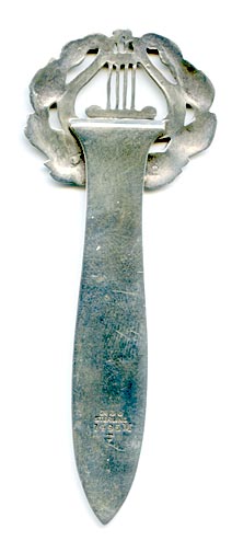 This bookmark was made in the US by Gorham Mfg. Co. It  is marked with the manufacturers hallmark, 1495M and an anchor as the date mark for 1887. The top is lyre surrounded by olive leaves.