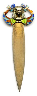 This silver and enamel Egyptian Revival bookmark was made in Europe in the 1920s. It is a hollow repousse relief depicting a pharoh's head with two ankhs and stylized flowers. The piece is finished in a gilt wash over. It is marked 800 on the back and likely dates to the time when the discovery of Tutankhamun's tomb inspired a new Egyptian Revival in design. The enamelled pharoah's head is set on a hinge, so it can be clipped over a page to help secure itself.