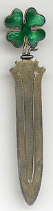 This bookmark is made in Norway by David Andersen. It is marked with his hallmark and 925. The David Andersen mark is described by the firm as a hammer and tong design, with the hammer in the center. It came into use in 1888. Norwegian law requires the degree of fineness to be followed by the letter S for silver. David Andersen chose to incorporate the S into their punch. Often the S was crossed by a diagonal line. It has an enamel four leaf clover on top and the blade is finished in a gold wash.