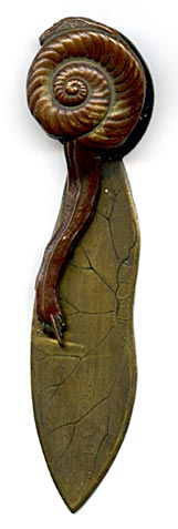 This bookmark is made in Japan between 1890 - 1910. It is made of brass and bronze with a figural snail as the top blade. It is also a clip where you can squeeze the shell part of the snail to raise the body to slip the page between.