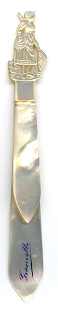 This bookmark was probably produced in France. It is made of mother-of-pearl and has a hand carved figural female maid holding a broom . The date is 1880 - 1900.
