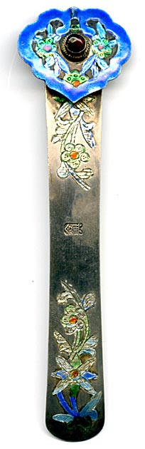 This bookmark was made in China. It is hallmarked with a Chinese symbol. The top has blue enamel with green and red flowers surrounding a brownish stone. The blade has inscribed enameled flowers.