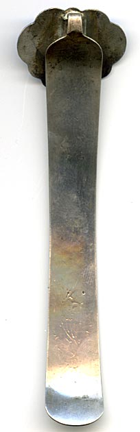 This bookmark was made in China. It is hallmarked with a Chinese symbol. The top has blue enamel with green and red flowers surrounding a brownish stone. The blade has inscribed enameled flowers.