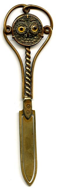 This bookmark was made in France. It is brass and the top is a relief picture of an owl with yellow glass eyes. The date is 1890 - 1910. 