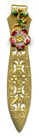 This bookmark was made in France. It is gold dorè and has an enamel flower and leaves which serves as the upper blade with a cutout longer blade.