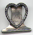 This bookmark is probably American made. It is in the shape of a heart with carved flowers. It is marked Sterling with an unknown hallmark on the back. The date of manufacture is unknown.