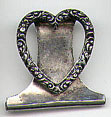 This bookmark is probably American made. It is in the shape of a heart with carved flowers. It is marked Sterling with an unknown hallmark on the back. The date of manufacture is unknown.