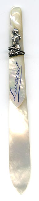 This bookmark was made in France. The top has a relief of Joan D'Arc in silver of her on her knees with her sword. It is mother of pearl and has the name Lusceuil on the top blade.