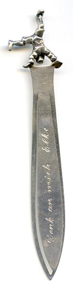 This bookmark was made in Germany. It is marked Dusseldorf and 800 on the back. The top is a clown doing a hand stand. The blade is inscribed "Denk an mich  Elke" which translates to “Think of me Elke”.