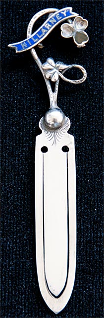 This bookmark was made in Great Britain by an unknown manufacturer. It is marked sterling but the hallmark is too warn to make out. The top has a banner in blue enamel with the word Killarney inlaid in silver. It also has a 3 leaf clover with green agate