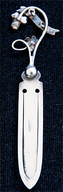 This bookmark was made in Great Britain by an unknown manufacturer. It is marked sterling but the hallmark is too warn to make out. The top has a banner in blue enamel with the word Killarney inlaid in silver. It also has a 3 leaf clover with green agate