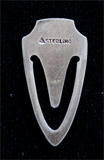 This bookmark is made in the US by F.A. Hermann Co. It is marked with the manufacturers hallmark and is also marked Sterling. The front is enamel with a picture of three roses.