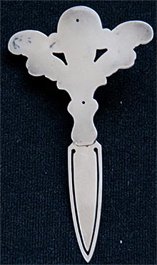 This bookmark is a William B. Kerr & Co. piece but it is unmarked. It has a large cherub with outstretched wings.