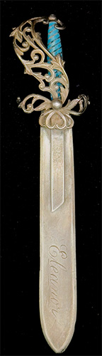 This bookmark was made in the US by H.H. Curtis, Inc. It is marked with the manufacturers hallmark, sterling and the number 700. The back in inscribed "Philopena". It is in the shape of a sword with a blue enamel grip and a fancy flowery hilt. The bottom blade is engraved Eleanor. The date is 1890 - 1910.