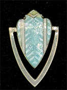 This bookmark was made in the US by F. A. Herman. It is marked with a hallmark of a triangle enclosing the letter H and sterling. The top is a cyan and black enamel shield. The date is 1900 - 1910.